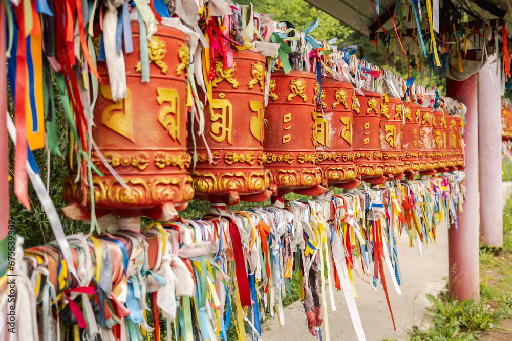 Rotating religious elements for touching turning spinning Buddhist prayer wheel at Buddhist monastery. Prayer wheels in Buddhist stupa temple. Buddhism religion concept