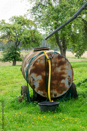 A large iron barrel is used to fill with rainwater.