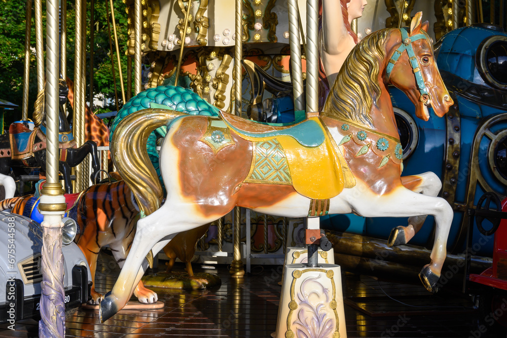 Colorful horse on traditional old french caroussel in city park in sunny day