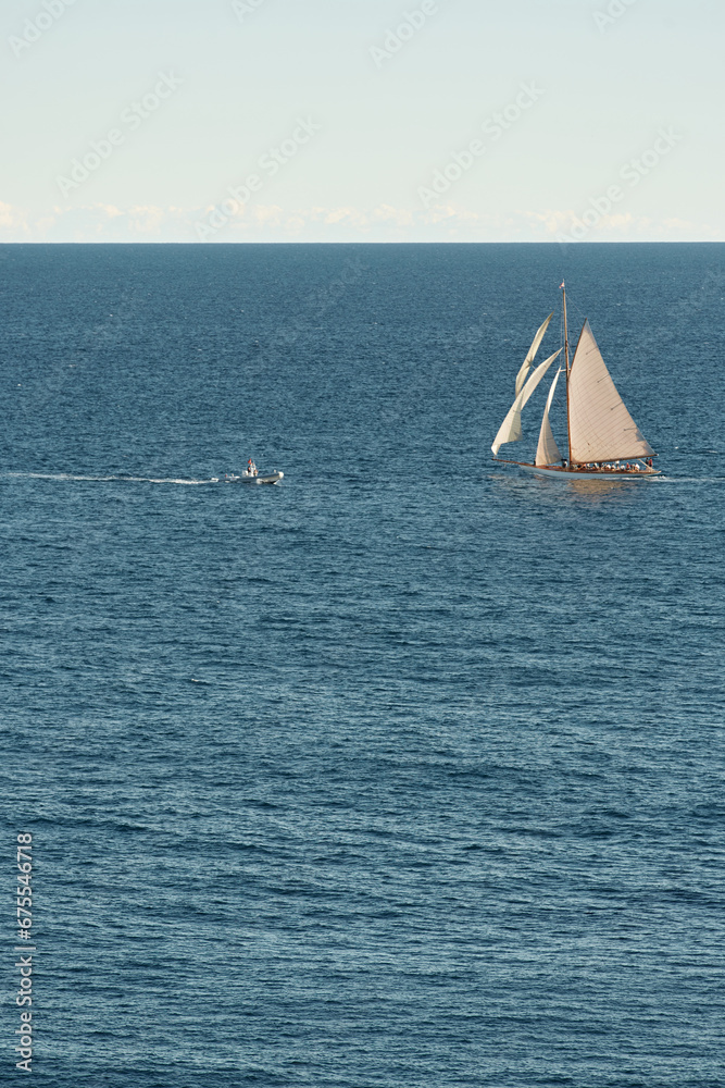 Monaco, lonely vintage sail yacht in sea at sunset, huge sail boat, wealth life of billionaires 