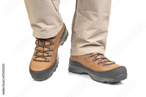 Trekking boots for hiking on the legs of a tourist on a white background. Equipment for travel and hiking