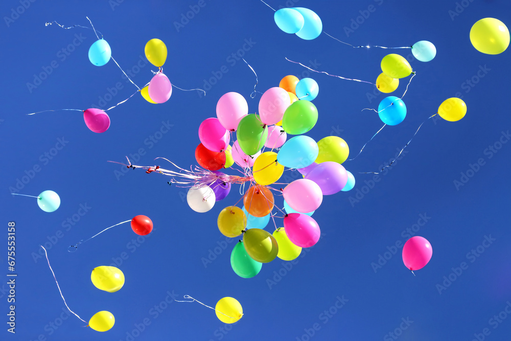 many multicolored balloons flying in the blue sky. Holiday accessories and decorations many multicolored balloons flying in the blue sky. Holiday accessories and decorations