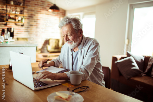 Senior man working on laptop from home