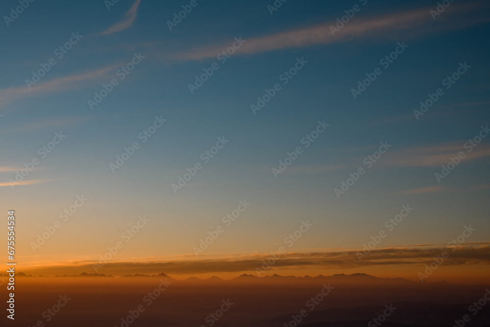 Amazing aerial view on mountain peaks during sunset. High mountain landscape in winter.