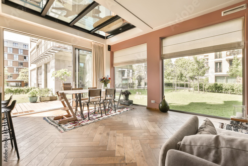 a living room with wood flooring and glass doors that open to the backyard area, which is covered in blinds photo