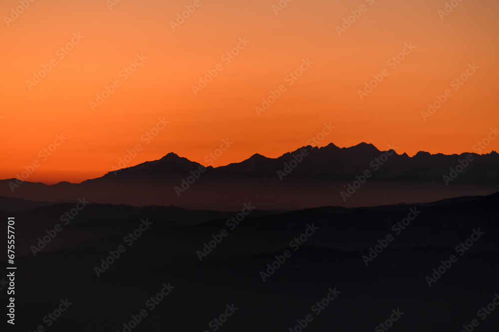 Fantastic winter landscape during sunset: colorful sky glowing by orange sunlight.