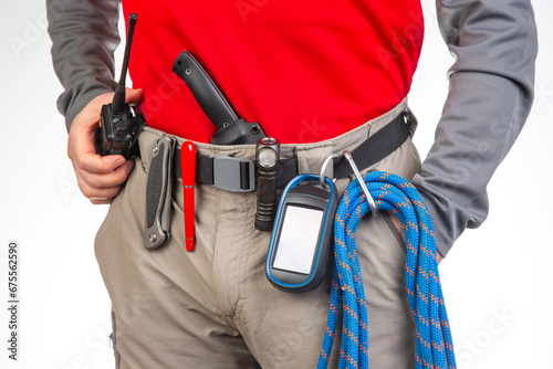 walkie-talkie, flashlight, knife, GPS navigator, climbing rope on the belt of the tourist trekking pants. equipment for tourism and travel. EDC items.