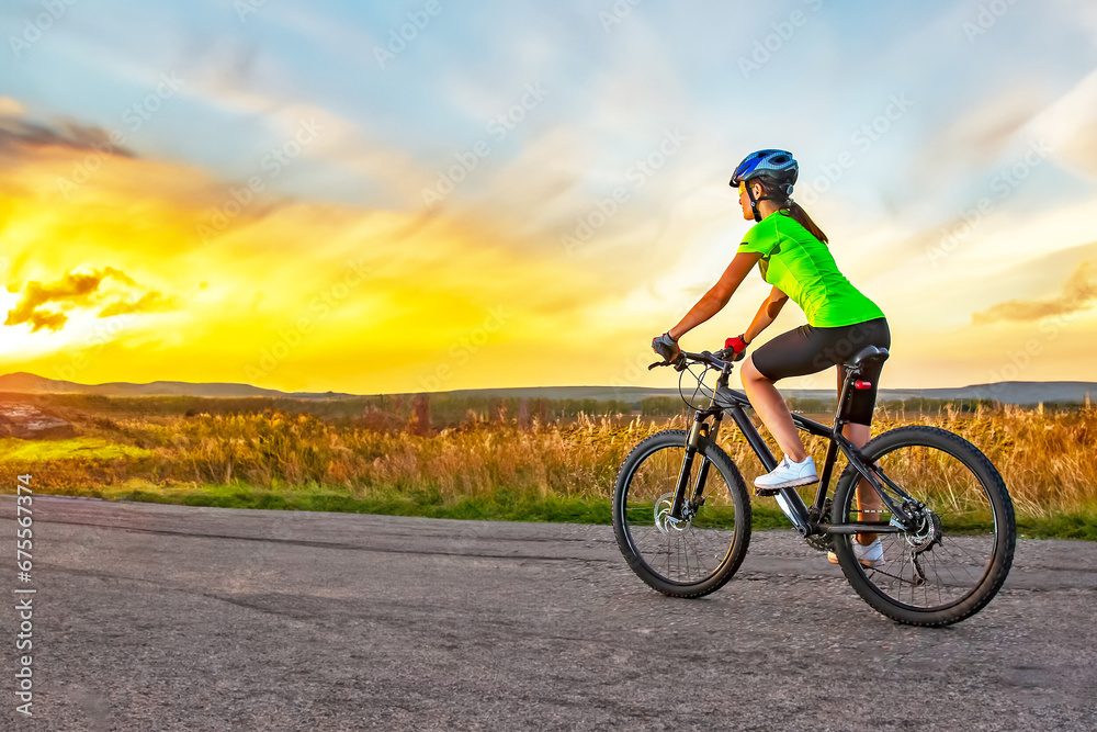 Beautiful woman cyclist rides a bicycle on a road. Healthy lifestyle and sports. Leisure and hobbies