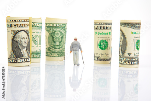 Miniature people. an elderly pensioner man stands near dollar money. concept of time and provision of old age