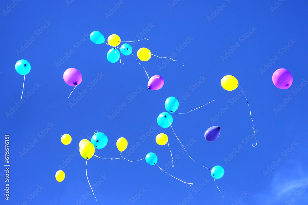 many multicolored balloons flying in the blue sky. Holiday accessories and decorations many multicolored balloons flying in the blue sky. Holiday accessories and decorations