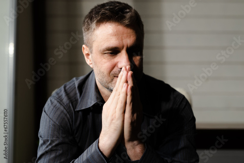 Man with praying hands. Male religious christian folded palms together asking god for help. Adult guy clasped arms pleading forgiveness of jesus christ  photo