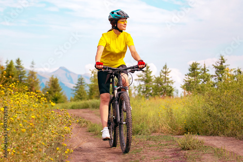 Beautiful woman cyclist rides a bicycle in nature. Healthy lifestyle and sports. Leisure and hobbies