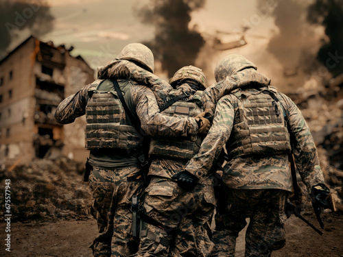 Fotografie Two army soldiers helping a wounded soldier between smoke and gas in destroyed c