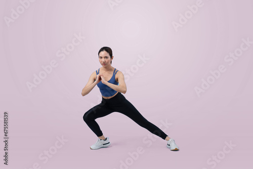 Young attractive asian woman in sportswear stretching before fitness exercise routine. Healthy body care workout with athletic woman warming up on studio shot isolated background. Vigorous © Summit Art Creations