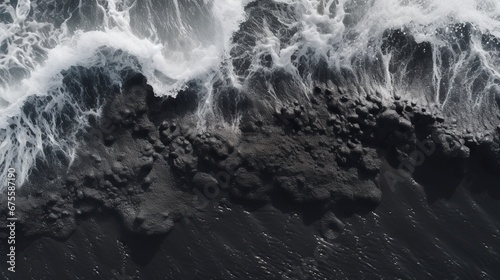 Waves striking the black sand . top shot