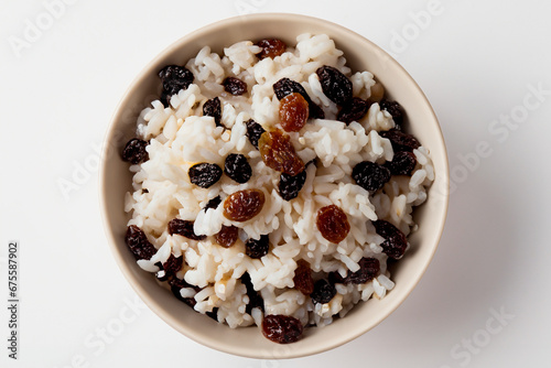 close-up de tigela de arroz branco cozido com uvas passas. Arroz com uvas secas no Natal. Comida Natalina com fundo branco, isolado. photo