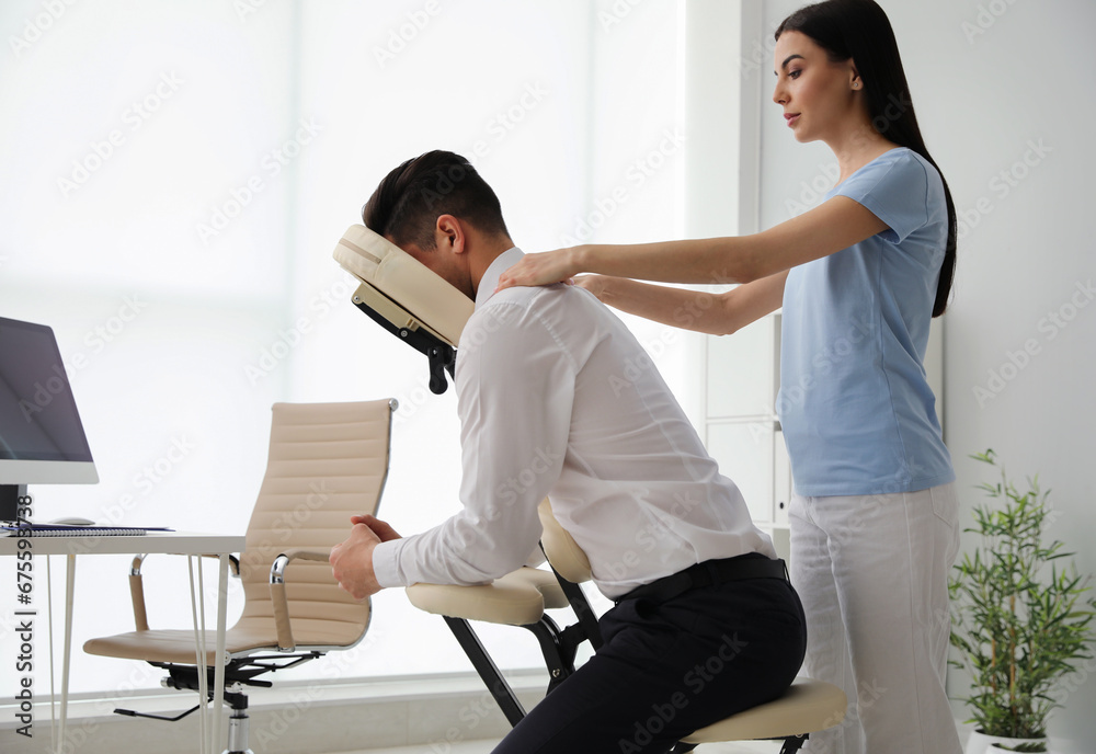 Fototapeta premium Man receiving massage in modern chair indoors