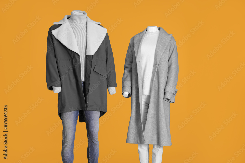 Mannequins dressed in stylish coat, jacket, sweater and turtleneck on orange background Mannequins dressed in stylish coat, jacket, sweater and turtleneck on orange background