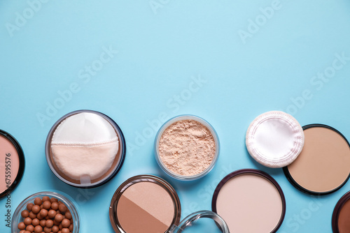 Different face powders on light blue background, flat lay. Space for text