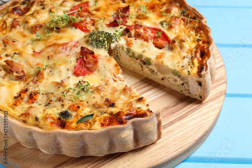 Tasty quiche with tomatoes, microgreens and cheese on light blue wooden table, closeup