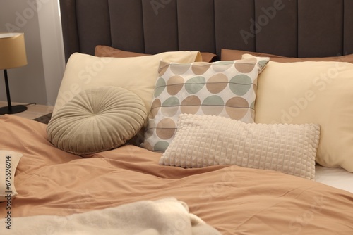 Large comfortable bed with soft pillows indoors. Home textile
