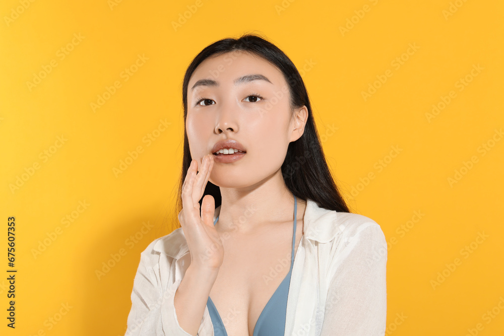 Beautiful young woman with makeup on orange background Beautiful young woman with makeup on orange background