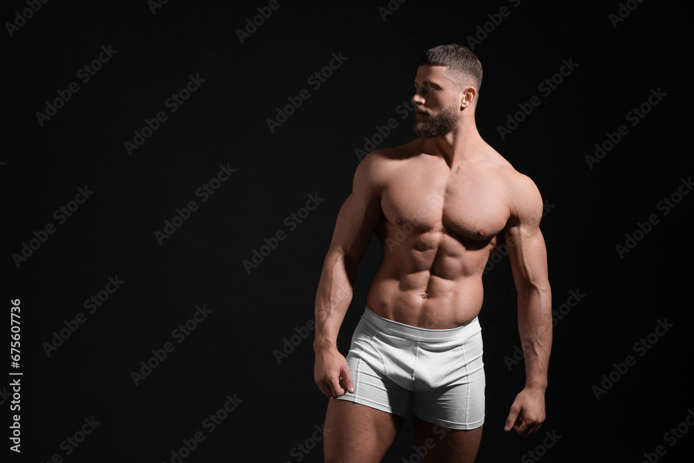 Young man in stylish white underwear on black background. Space for text