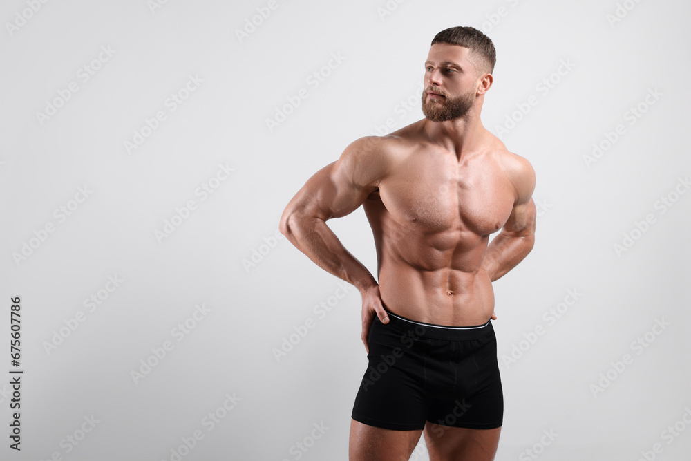 Young man is stylish black underwear on light grey background. Space for text Young man is stylish black underwear on light grey background. Space for text