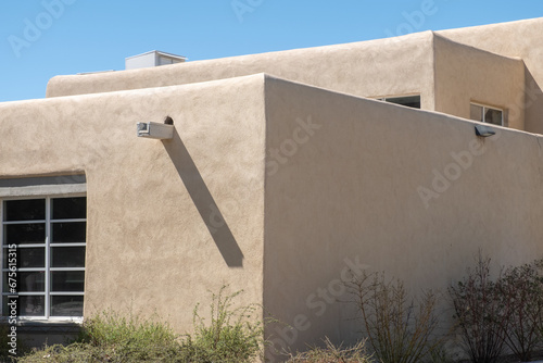 Architectural detail of a southwest style building. Half the building is in direct sunlight and half is shaded.