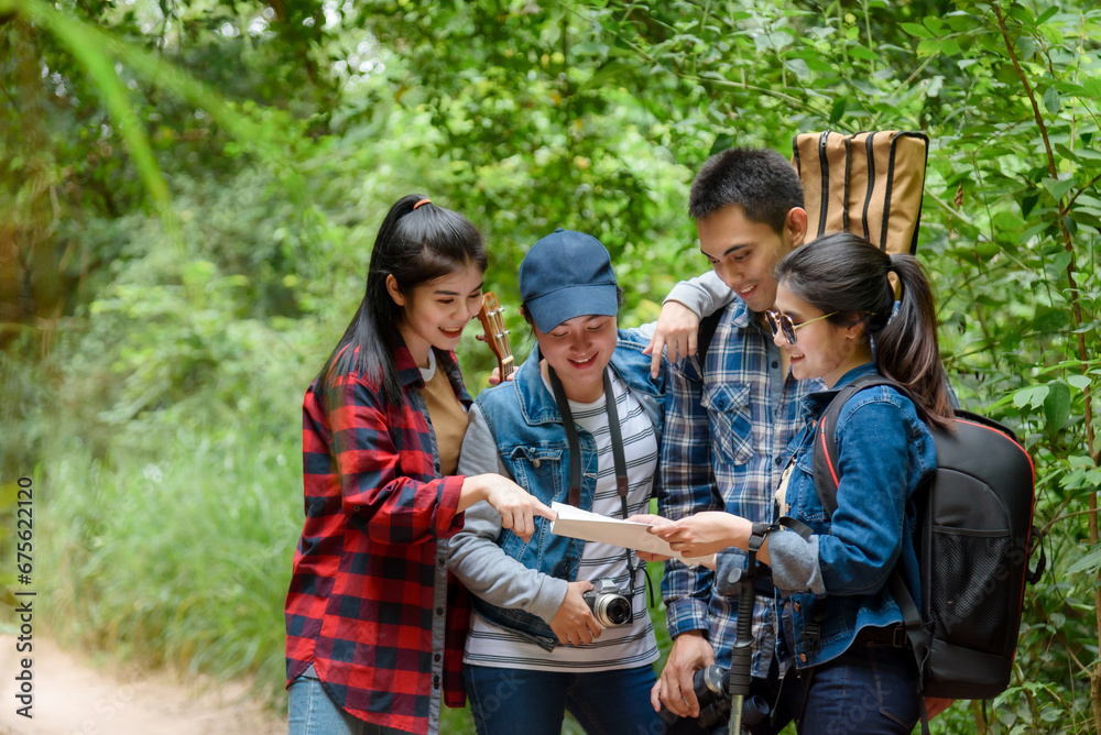 Group of friends walking on an adventure in the forest Look at the map to explore the forest and plan as a team. Group of friends walking on an adventure in the forest Look at the map to explore the forest and plan as a team.