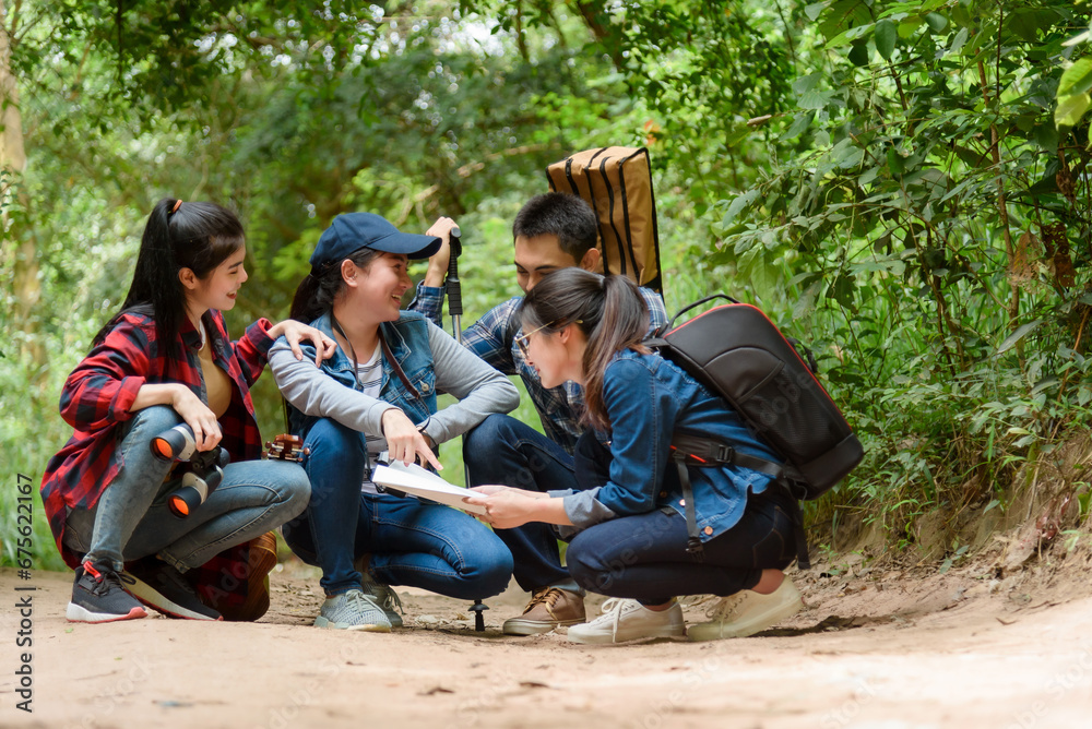 Group of friends walking on an adventure in the forest Look at the map to explore the forest and plan as a team. Group of friends walking on an adventure in the forest Look at the map to explore the forest and plan as a team.