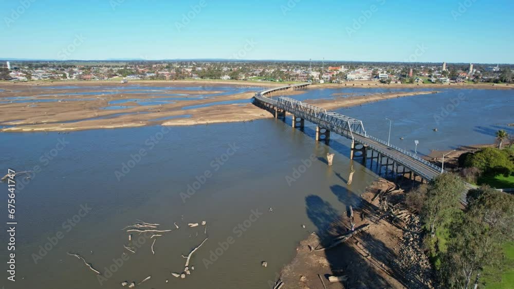Aerial moving across the mud and water of Lake Mulwala towards the bridge and Yarrawonga beyond Aerial moving across the mud and water of Lake Mulwala towards the bridge and Yarrawonga beyond