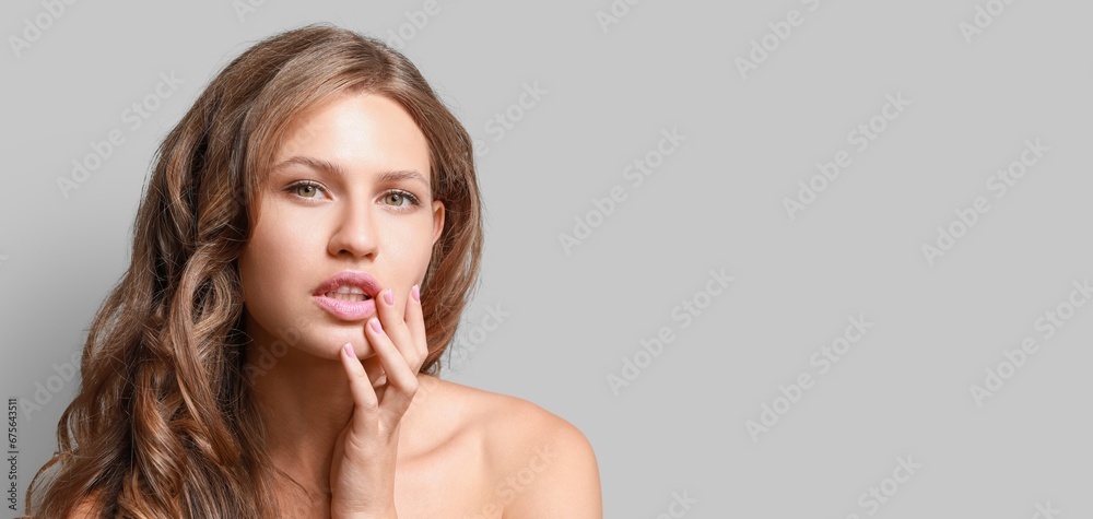 Beautiful young woman with nude makeup on grey background with space for text Beautiful young woman with nude makeup on grey background with space for text