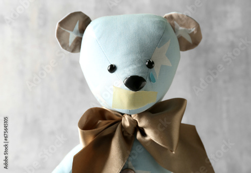 Toy bear with taped mouth a...