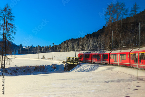 Red passenger train on Rhaetian railway in Canton Graubunden, Switzerland at winter