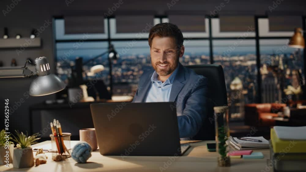 Smiling businessman taking coffee sip office night closeup. Boss looking laptop Smiling businessman taking coffee sip office night closeup. Boss looking laptop