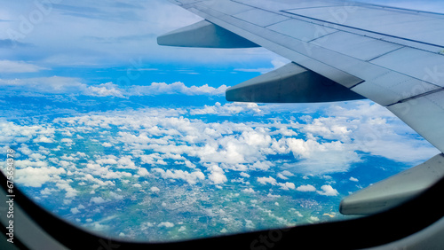 Aerial view of sky and clouds through an airplane window. Travel concept. traveler, trip, vacation, tourism, landscape, vibrant, nature, scenery, background © Tanawat Thipmontha