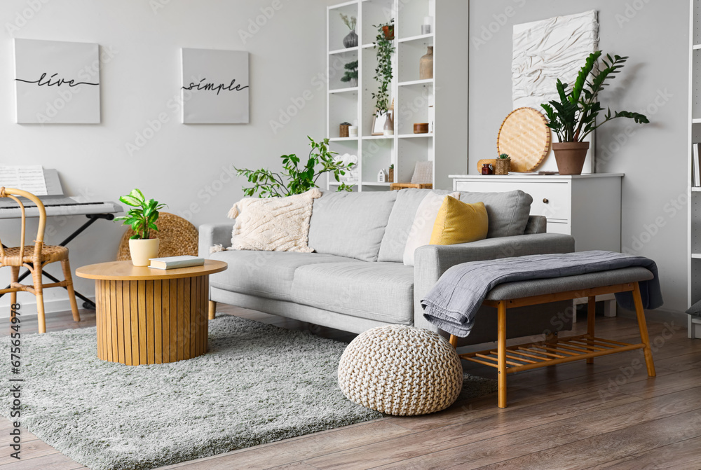 Interior of modern living room with grey sofa, coffee table, pouf and bench - obrazy, fototapety, plakaty 