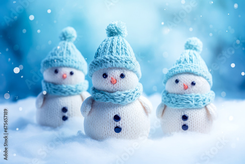 Cute snowmen in knitted hats and scarves on winter background © mila103