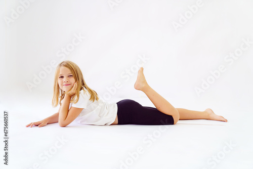 Cheerful teenage girl in white t-shirt and black breeches on white background