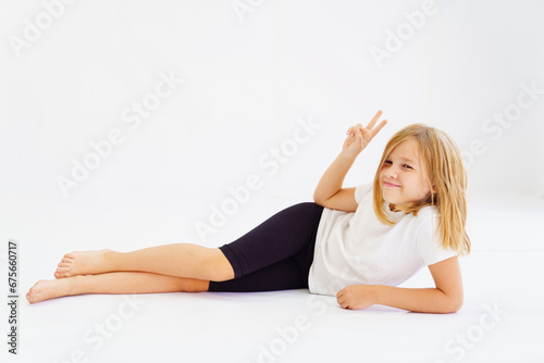 Cheerful teenage girl in white t-shirt and black breeches on white background
