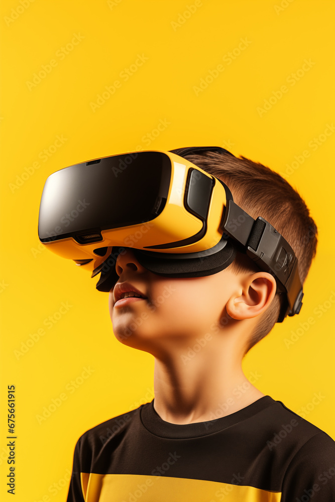 Young boy getting experience using VR headset glasses isolated on a yellow background