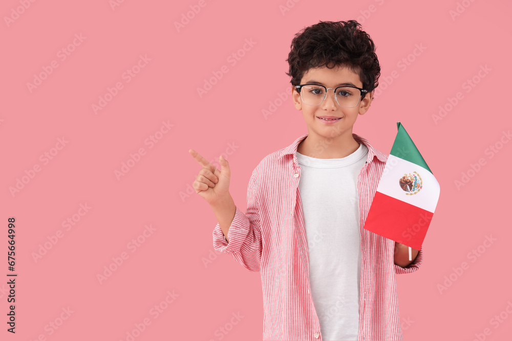 Little boy with Mexican flag pointing at something on pink background Little boy with Mexican flag pointing at something on pink background