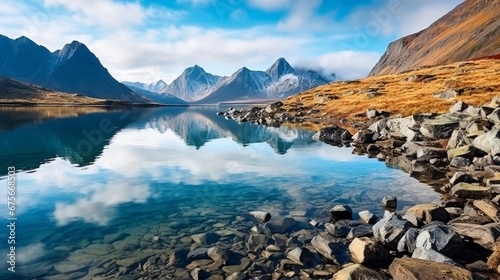 Landscape of lake Tahtarjavr with transparent water, rocky bottom and distant mountains reflected in still morning waters, Hibiny mountains above the Arctic circle, Russia