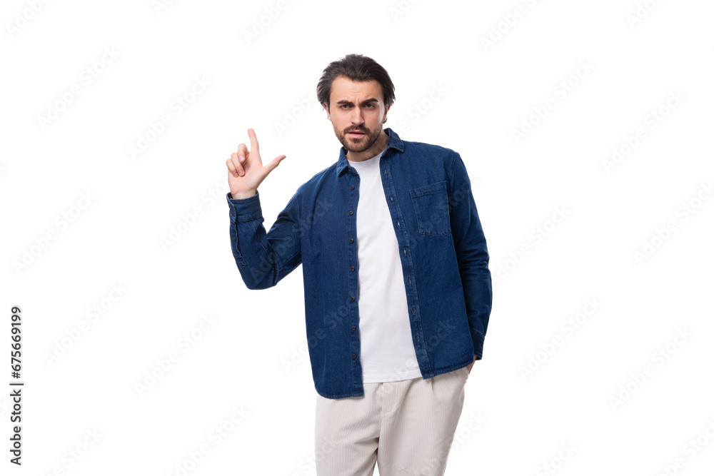 handsome well-groomed young brunette man in a denim shirt wants to tell interesting news handsome well-groomed young brunette man in a denim shirt wants to tell interesting news