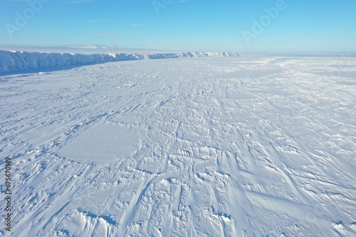 Landscape with snow. Aerial view of an empty field covered with snow and an ice wall.