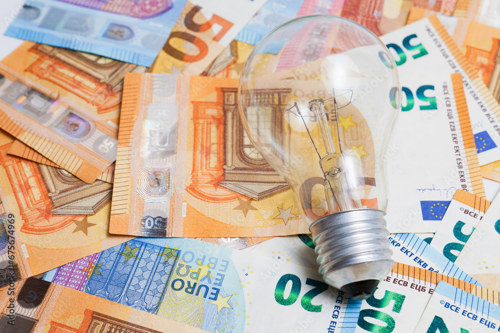 light bulb on a pile of euro banknotes, electricity price increase