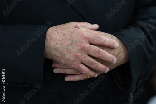 Photos A man's hands resting on his stomach while standing upright