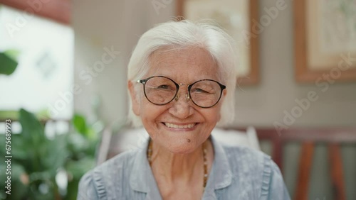Happy Asian elderly woman wearing denture smilling to camera. Grandmother using dental prosthesis. Insertion of dentures. Dental concept. Flexible nylon denture photo