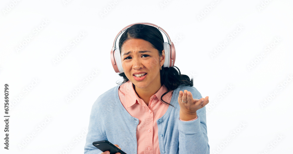 Woman, confused and smartphone in portrait in headphones, music and streaming in question in studio mockup. Young person, asian and doubt on face, audio playlist and online radio by white background Woman, confused and smartphone in portrait in headphones, music and streaming in question in studio mockup. Young person, asian and doubt on face, audio playlist and online radio by white background